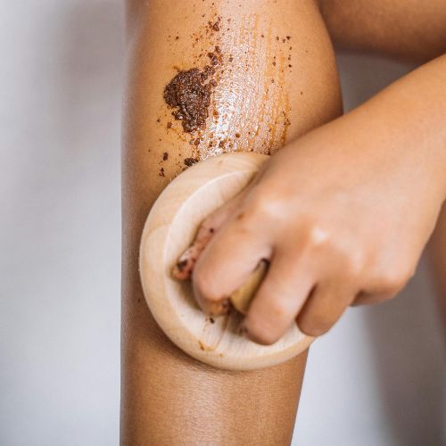 person scrubbing her legs doing exfoliation