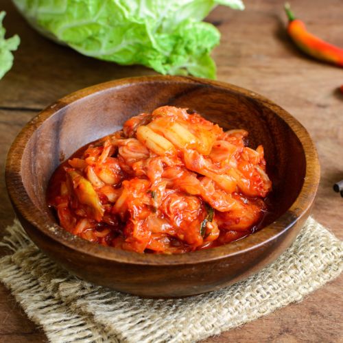 vibrant red kimchi in a traditional Korean ceramic bowl